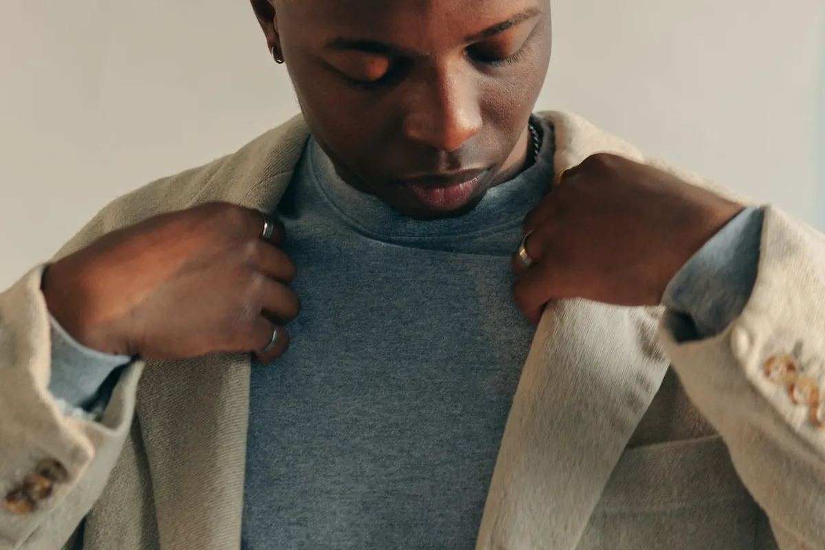 Homme ajustant les revers d'un manteau beige